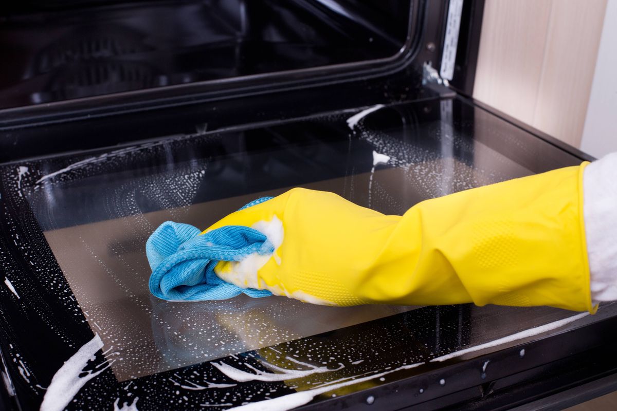 Person cleaning oven door