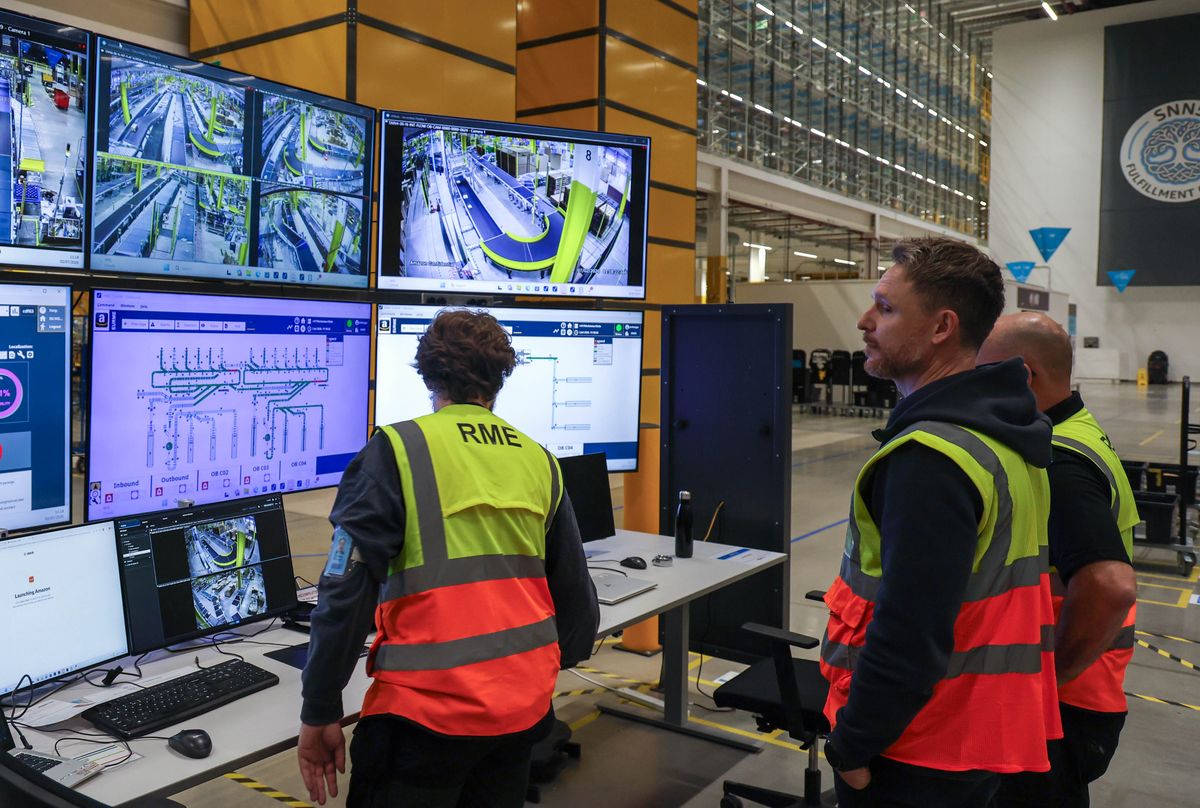 Associates monitor the operation of the warehouse