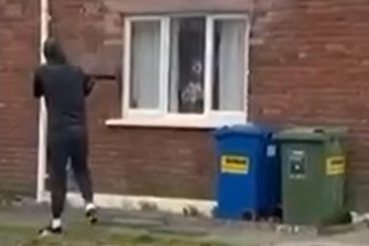 The gunman is caught on camera as he shoots at the house