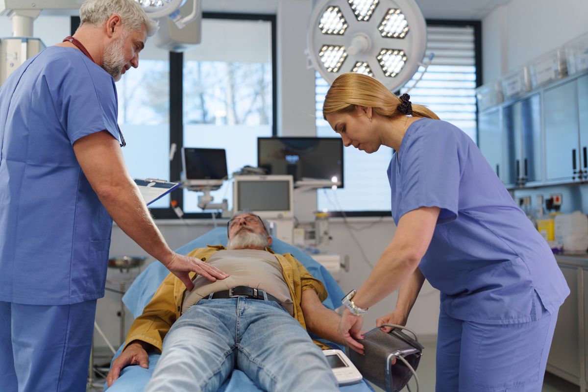 Emergency room in hospital. ER doctor examining patient in hospital bed.