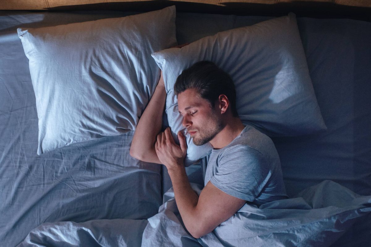 Top View Apartment Bedroom: Handsome Young Man Sleeping Cozily on a Bed in His Bedroom at Night. Comfortable Apartment with Guy Resting for Productive next Day. Top Down Above