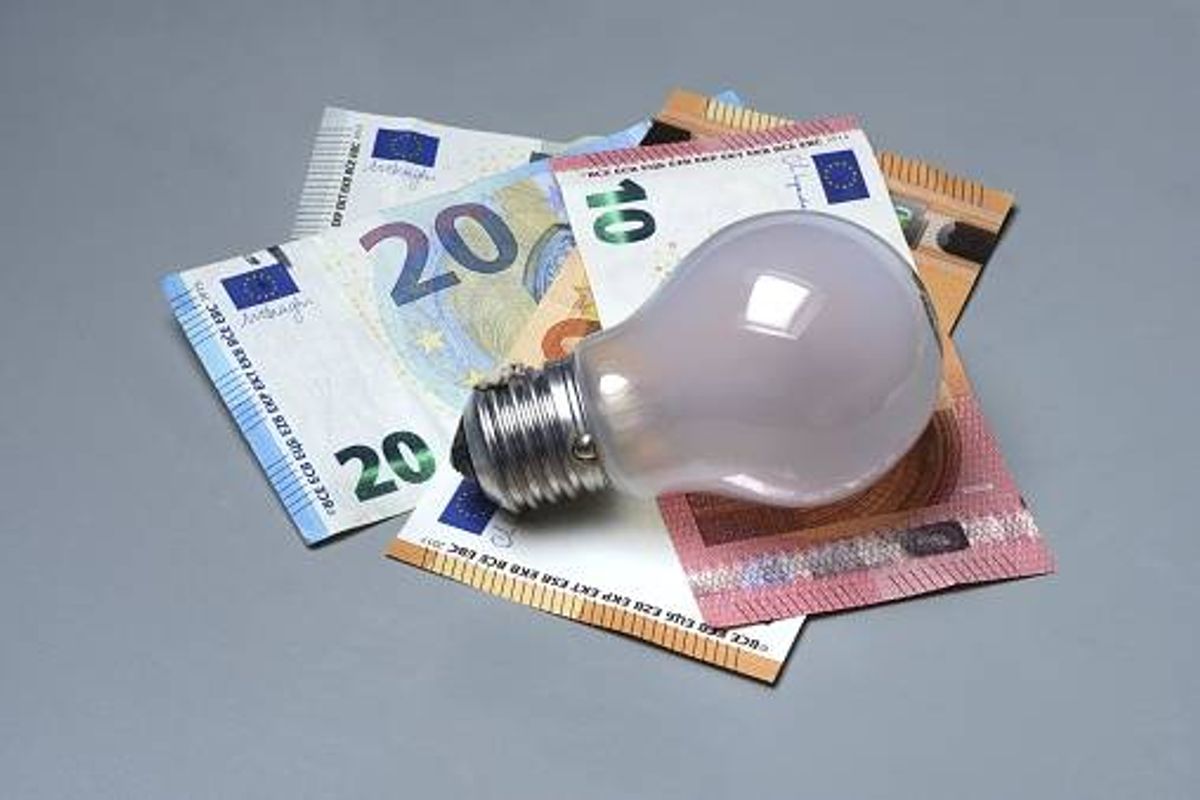 Banknotes and light bulbs, electricity costs - stock photo