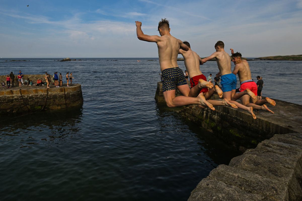 Swimmers jump into the sea from Colliemore harbour pier in Dalkey, on May 11, 2024, in Dalkey, Dublin, Ireland. (Photo by Artur Widak/NurPhoto via Getty Images)