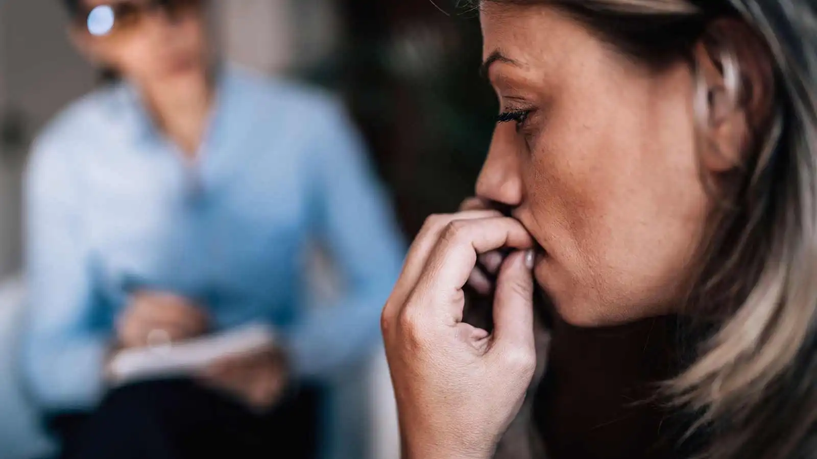 Woman with anxiety talking to mental health professional.
