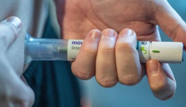 A photo of a man self-injecting his abdomen with a tirzepatide injection pen.