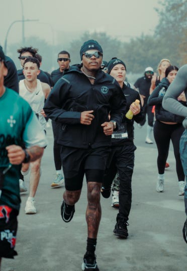 A group of diverse runners participating in a marathon on a foggy day.