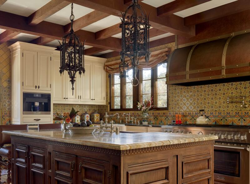 A kitchen with yellow tile and antique lighting fixtures.