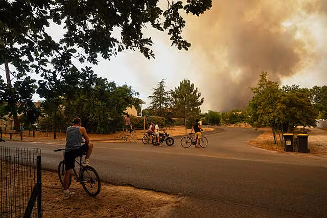 People watch massive plumes of smoke caused by wildfires in western France