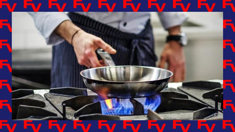 Hand reaching for a stainless steel pan that sits over a gas stove flame; photo in FV branded border