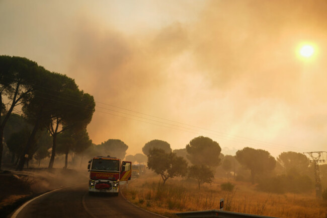 fire-engines-stop-on-a-road-as-smoke-rises-from-a-wildfire-in-san-martin-de-valdeiglesias-west-of-madrid-spain-sunday-july-26-2026-ap-photomanu-fernandez