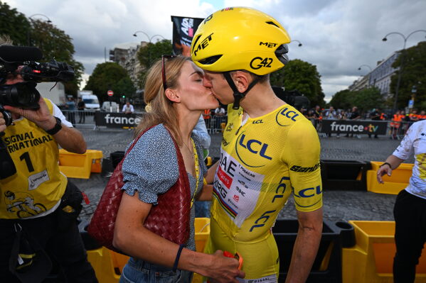 Slovenia's Tadej Pogacar, wearing the overall leader's yellow jersey, celebrates with his girlfriend Urska Zigart after the the last stage of the Tour de France cycling race in Paris, Sunday, July 26, 2026. (AP Photo/Dario Belingheri/Pool Photo via AP)