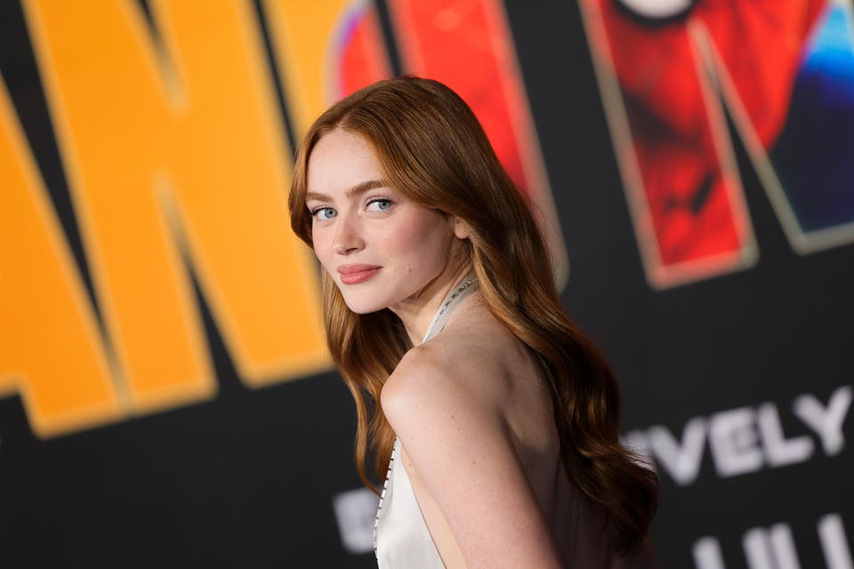 A woman with long, red hair wearing a white gown