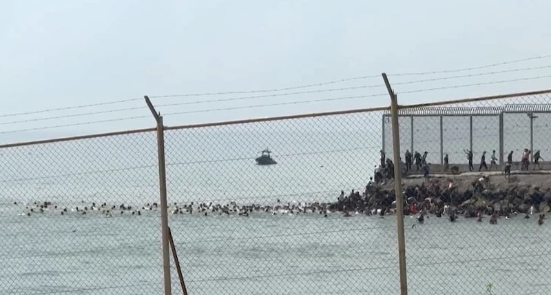 Migrants swim in the sea to reach a beach in Ceuta. Photograph: Lucía Diaz/AFP via Getty Images