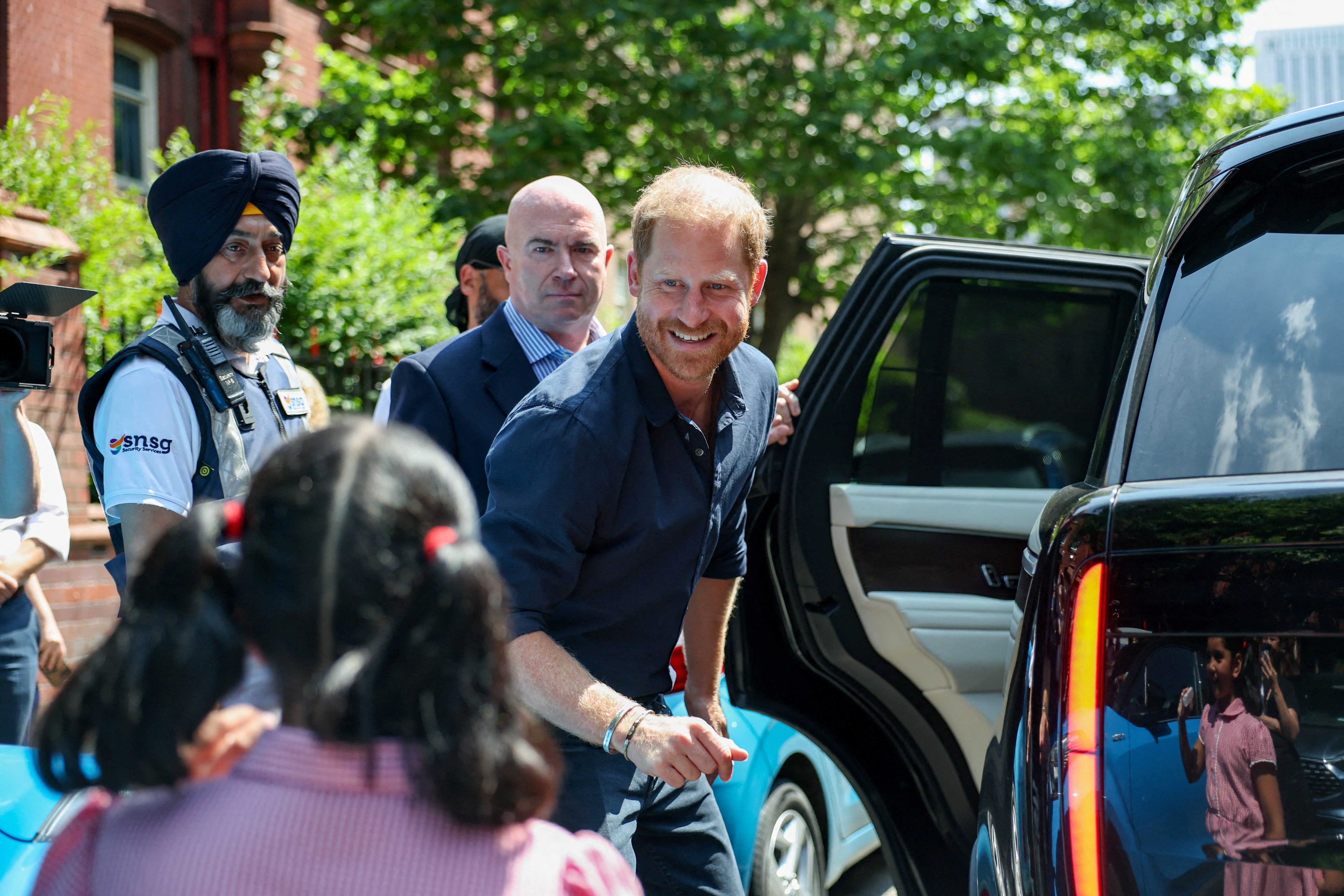 Britain's Prince Harry greets a child as he leaves the Birmingham Children's Hospital after celebrating the 20th anniversary of the first WellChild Nurse programme