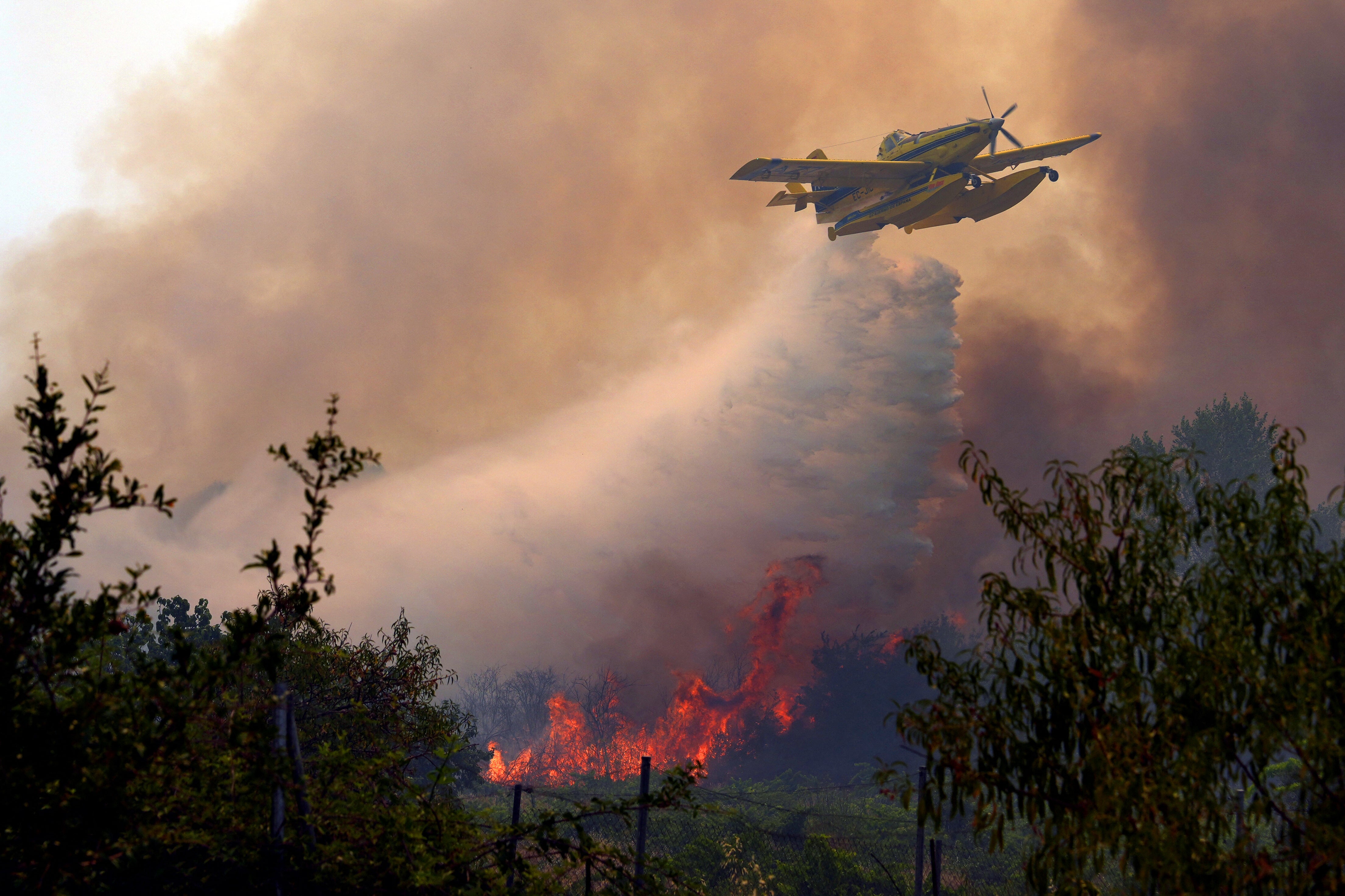 An Air Tractor AT-802F Fire Boss aircraft dumps water over a wildfire burning near San Martin de Valdeiglesias, about 70km west of Madrid