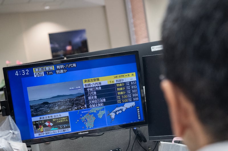 Reporters watch the news showing a large quake and possible one-metre tsunami wave in southern Japan. Photograph: Andrew Caballero-Reynolds/Getty