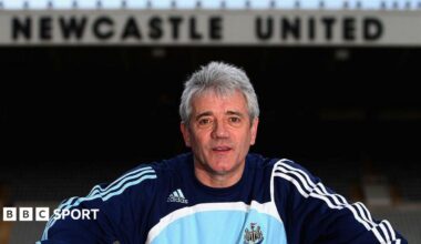 Kevin Keegan posing for a photo inside St James' Park, with the Newcastle United lettering on the East Stand behind him