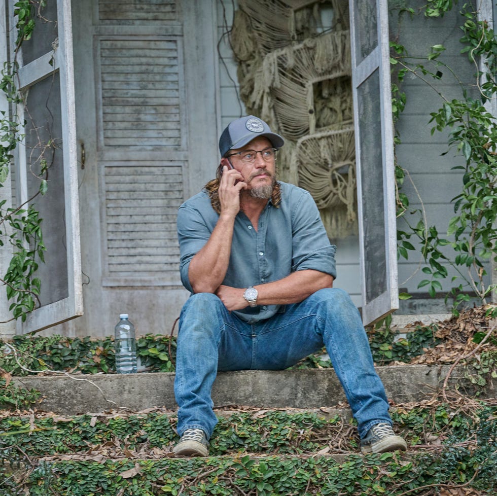 man sitting on porch steps, talking on phone, surrounded by greenery. man sitting on porch steps, talking on phone, surrounded by greenery.