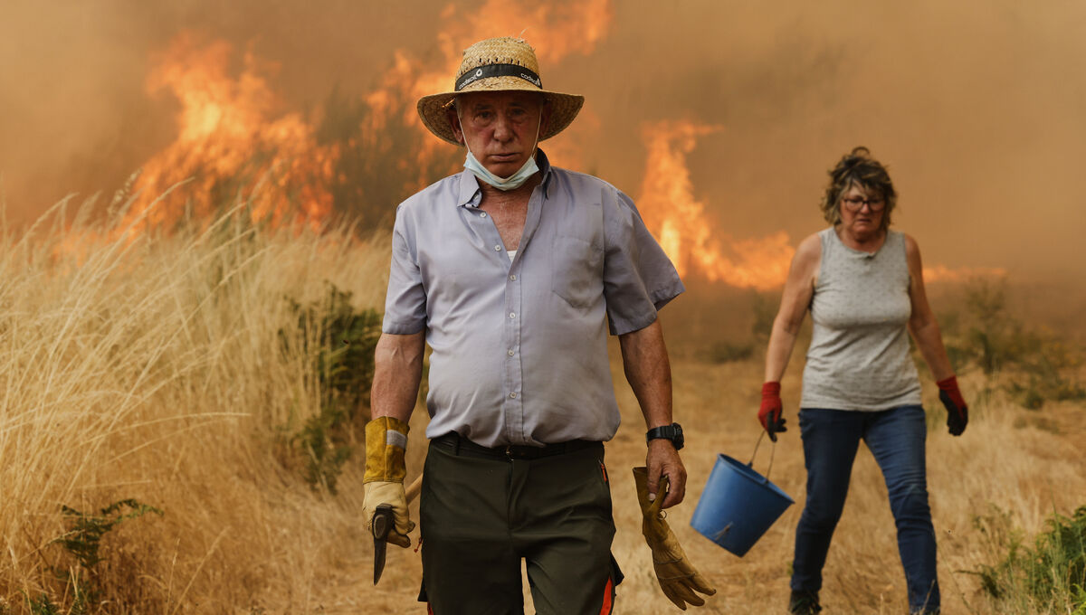 Local residents do what they can to fight the flames during a wildfire in Santa Baia De Montes, northwestern Spain, in August last year. Picture: AP
