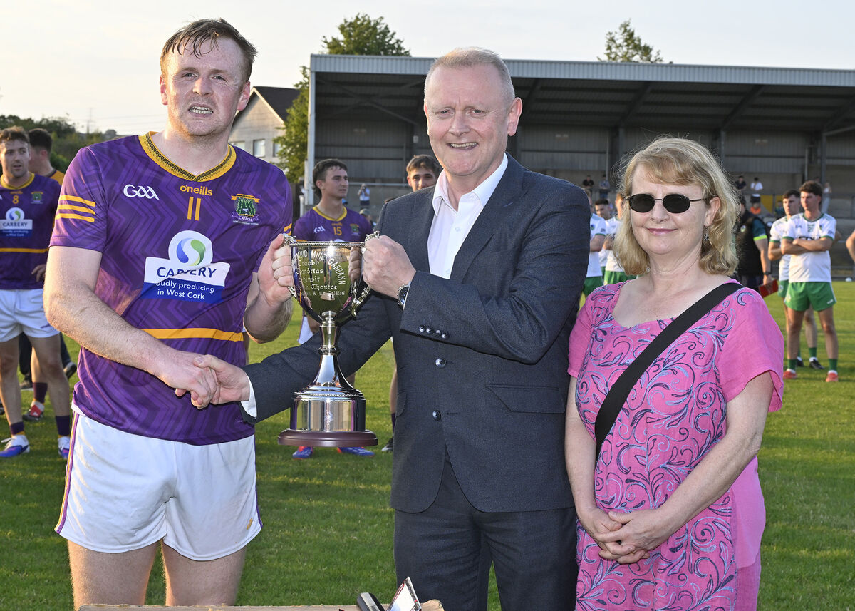 Diarmuid Gowen presents the Derry Gowen Cup to Carbery captain Damien Gore. Picture: Martin Walsh