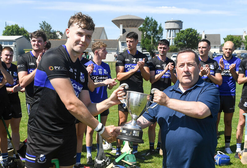  Jim McEvoy, Cork GAA, presents the cup to Sarsfields captain Jack Leahy after they defeated Aghada in the Division 6 Hurling League final in Cobh. Picture: David Keane.