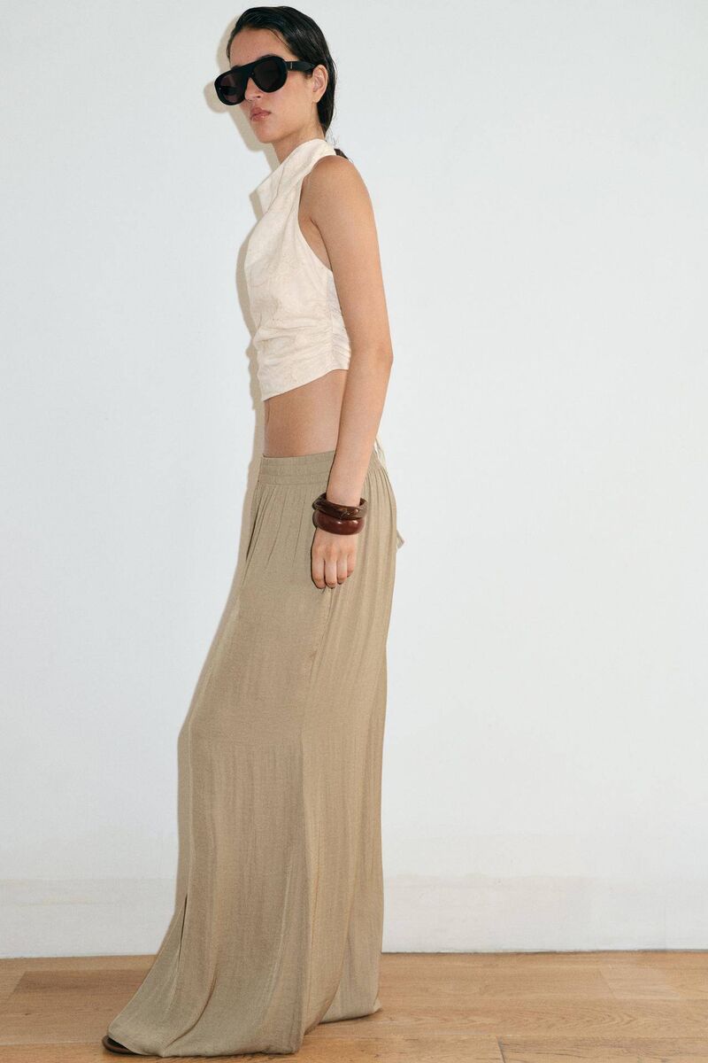 A model wearing Zara's flowy wide-leg trousers