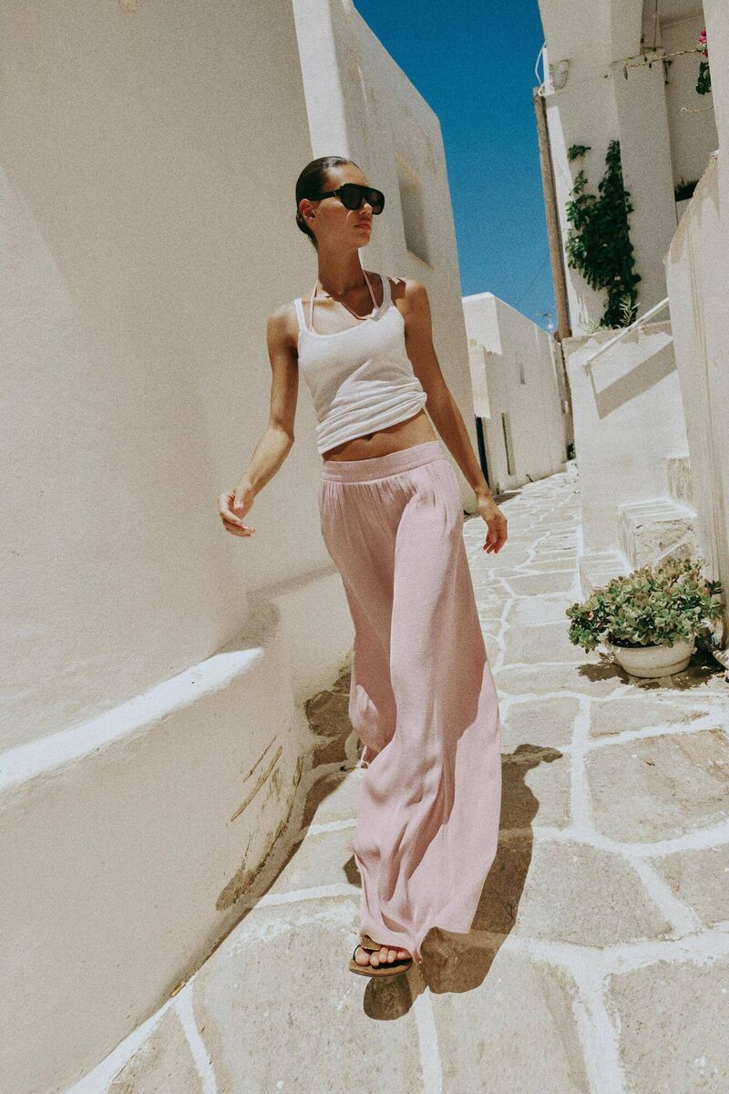 A model walks while wearing Zara's flowy wide-leg trousers