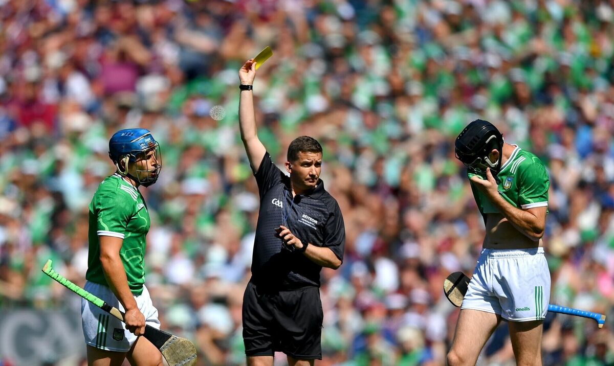 Referee Colm Lyons shows a yellow card to Mike Casey of Limerick. Picture: Stephen McCarthy/Sportsfile
