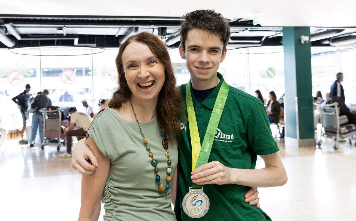 Member of Team Ireland Ben Maguire is greeted by his mother Rebecca Maguire after he returned from the International Maths Olympiad after arriving from China at Dublin Airport. Photo: Gareth Chaney