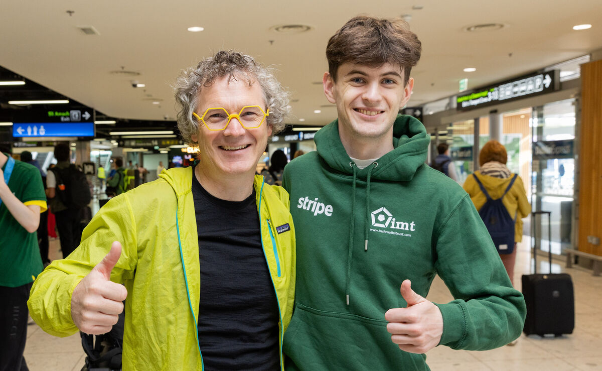 Member of Team Ireland Owen Barron (right) with his father Ian Barron after Owen returned from the International Maths Olympiad arriving from China at Dublin Airport. Photo: Gareth Chaney