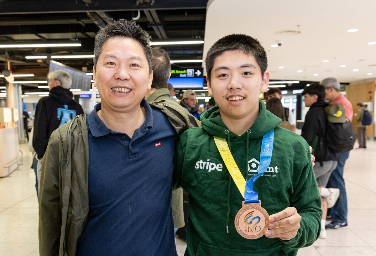 Member of Team Ireland Angyang Li (right) is greeted by his father Joe Li after he returns from the International Maths Olympiad from China at Dublin Airport. Photo: Gareth Chaney