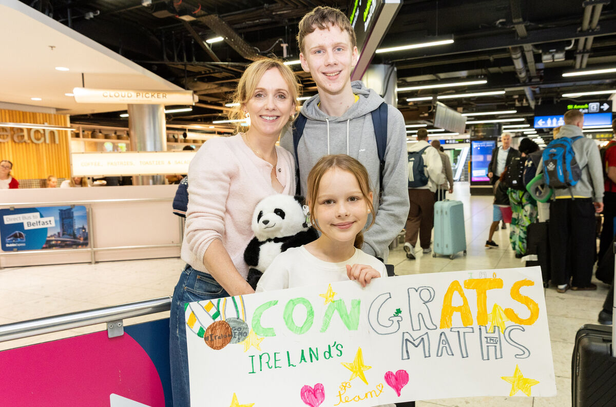 Member of Team Ireland Jack McAuliffe is greeted by his mother Sinead and his sister Aibhaín after he returns from the International Maths Olympiad after arriving from China at Dublin Airport. Photo: Gareth Chaney
