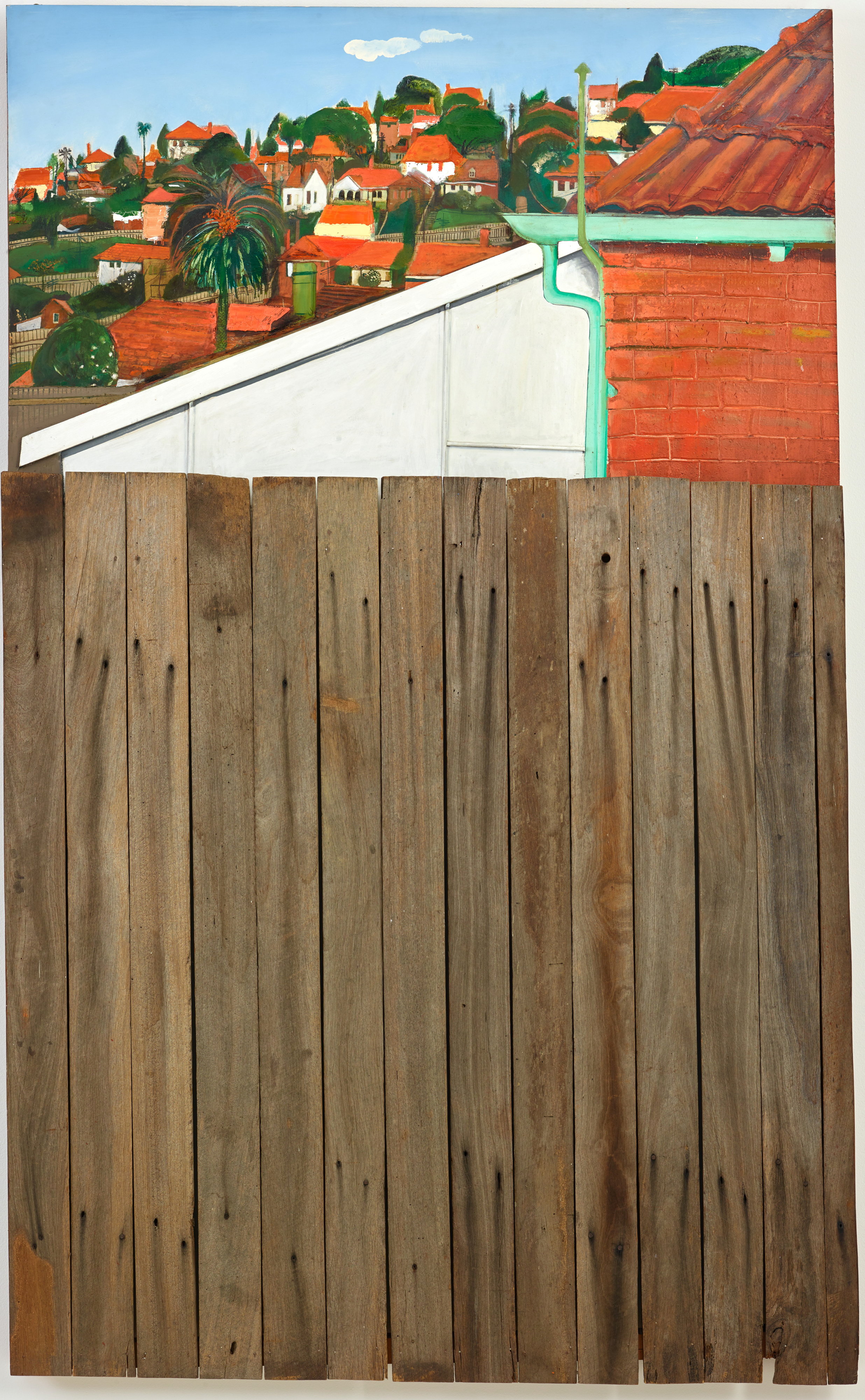 A painting of the side of a red-brick house, the red-roofed suburbs behind it. Wooden fence posts are affixed at bottom.