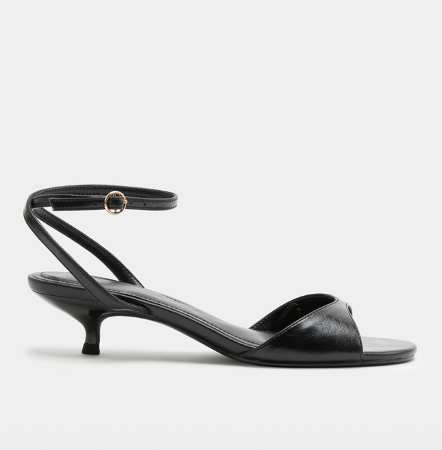Black strappy sandal with kitten heel and ankle strap on white background. black strappy sandal with kitten heel and ankle strap on white background.