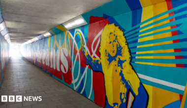 A photo of a colourful mural painted on a subway, which includes an illustration of Led Zeppelin's Robert Plant.