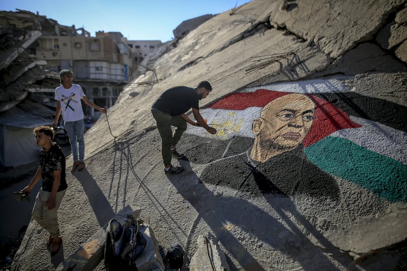 Palestinian artist Obai Al-Karshali paints a portrait of Egyptian National Football Team head coach Hossam Hassan on the rubble of a building. Photograph: Saeed M M T Jaras/Anadolu via Getty Images