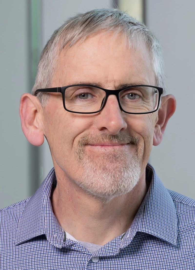 Portrait of Scott Reed, a man with short hair, glasses, and a goatee.