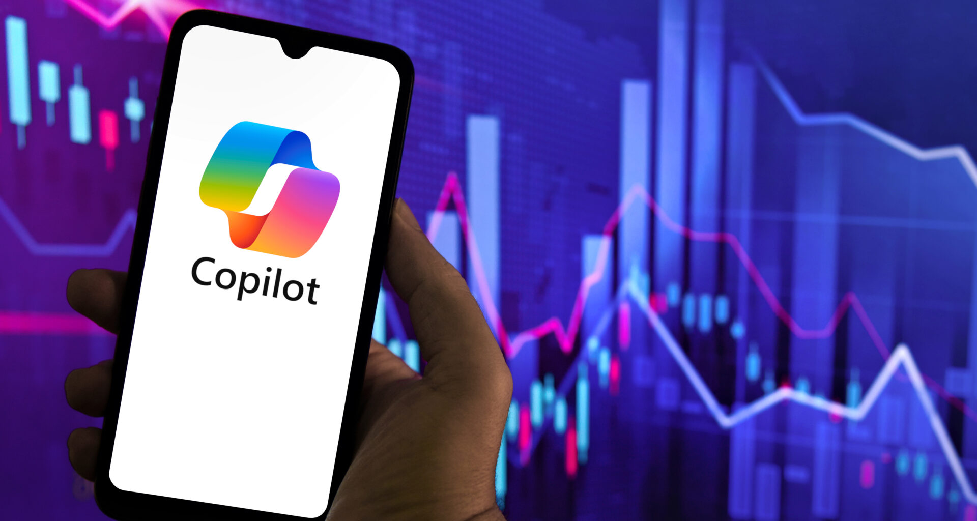 Copilot logo on a smartphone in front of a financial graph