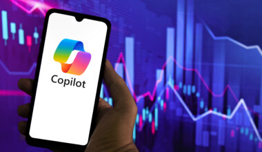 Copilot logo on a smartphone in front of a financial graph