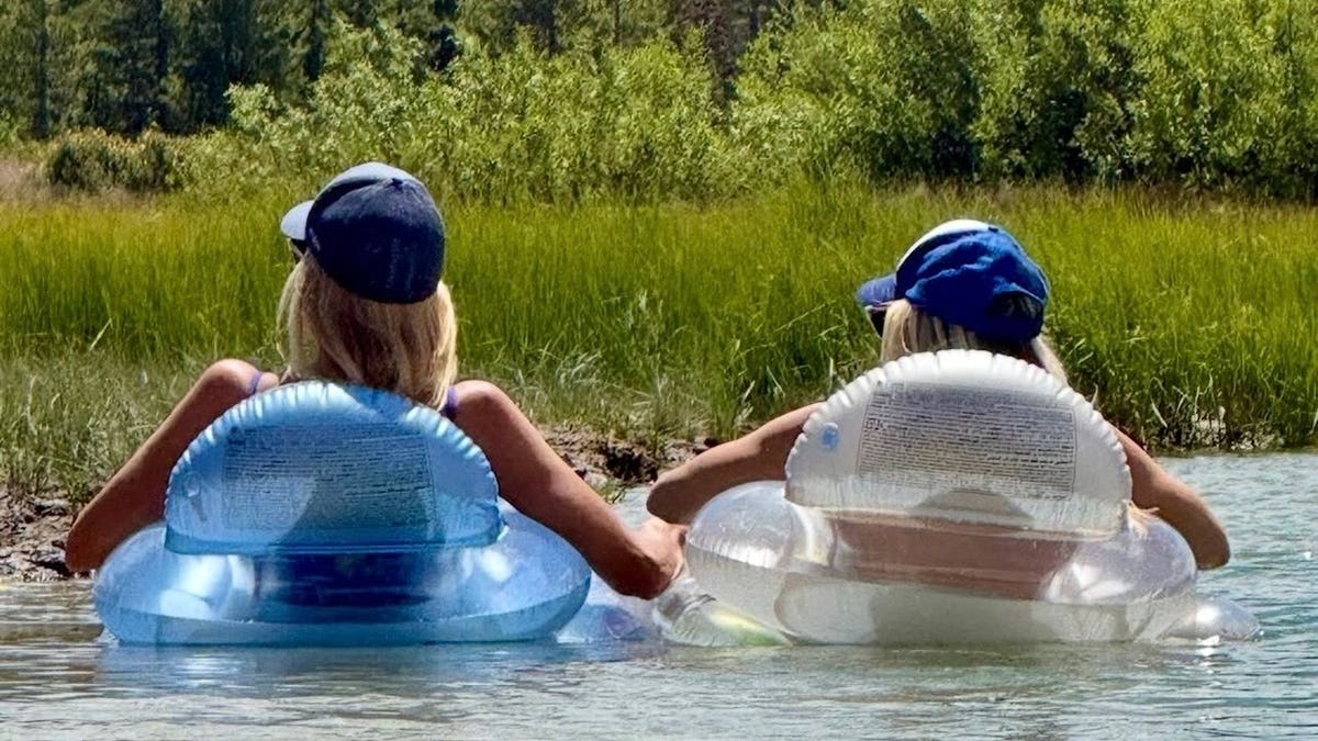 Ali Larter relaxes in an inflatable float alongside a friend while drifting on the water during a Fourth of July mountain getaway.