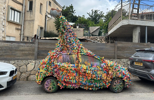 Artist Sam Halaby's paint-covered car sits outside his House of Colors in Daliyat al-Karmel, where it serves as both transportation and a mobile work of art 