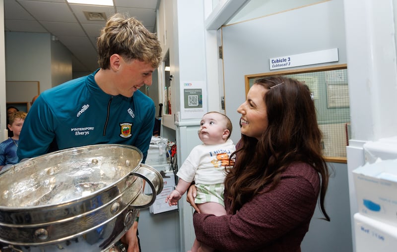 Mayo's Kobe McDonald with patient Coby Smith (eight months), and his mother Emma Smith, from Ballybrack,  as Mayo team members visited Temple Street Children's Hospital with the Sam Maguire. Photograph: Tom Maher/Inpho