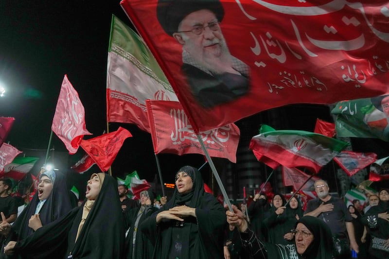 Demonstrators wave Iranian and religious flags including one depicting late supreme leader Ali Khamenei, in Tehran. Photograph: Vahid Salemi/AP