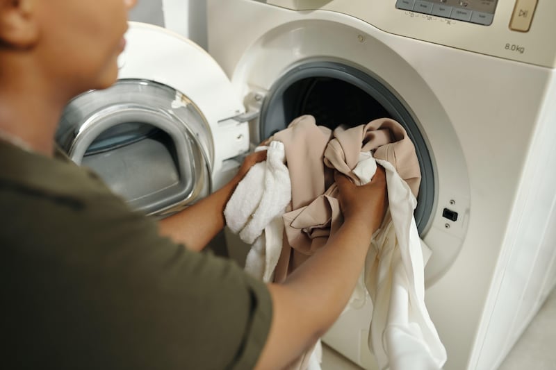 2Y6YD2N Loading Laundry in Washing Machine at Home
