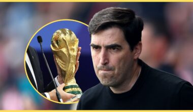 Liverpool manager Andoni Iraola looks on during Premier League game next to World Cup trophy.