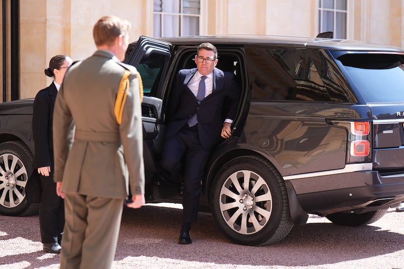 The king's equerry, Maj Ben Rigby (left), greets Labour Party leader Andy Burnham as he arrives at Buckingham Palace, London. Photograph: Aaron Chown/PA Wire