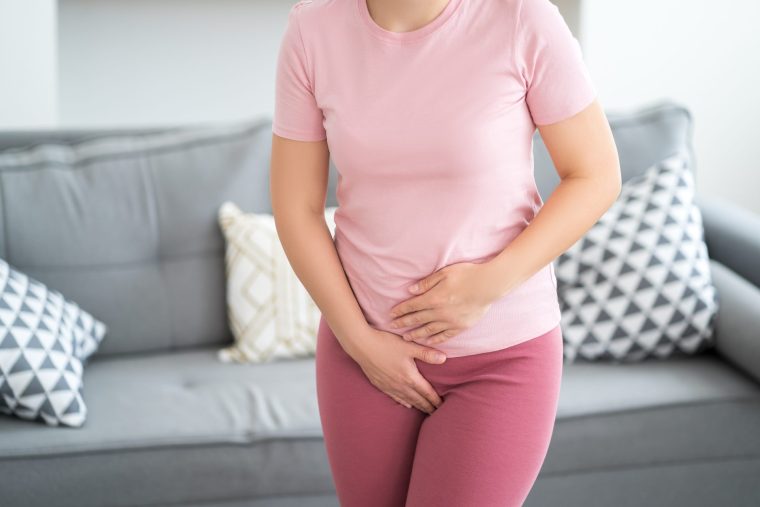 Menstrual pain, woman with stomachache suffering from pms at home, endometriosis, cystitis and other diseases of the urinary system - stock photo
