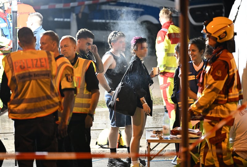 Police, emergency personnel and attendees of the Pride event near the scene where one person was killed and around 16 injured after a car struck people. Photograph: Ralf Hirschberger/AFP via Getty Images