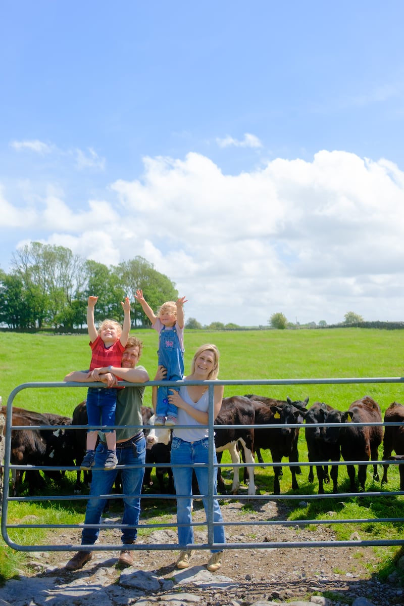 Mark Ryan and Louise Butler with their children Sonny and Ferne, who are fully immersed in farming life, feeding the calves and collecting their hens' eggs. Photograph: Pedro Souza