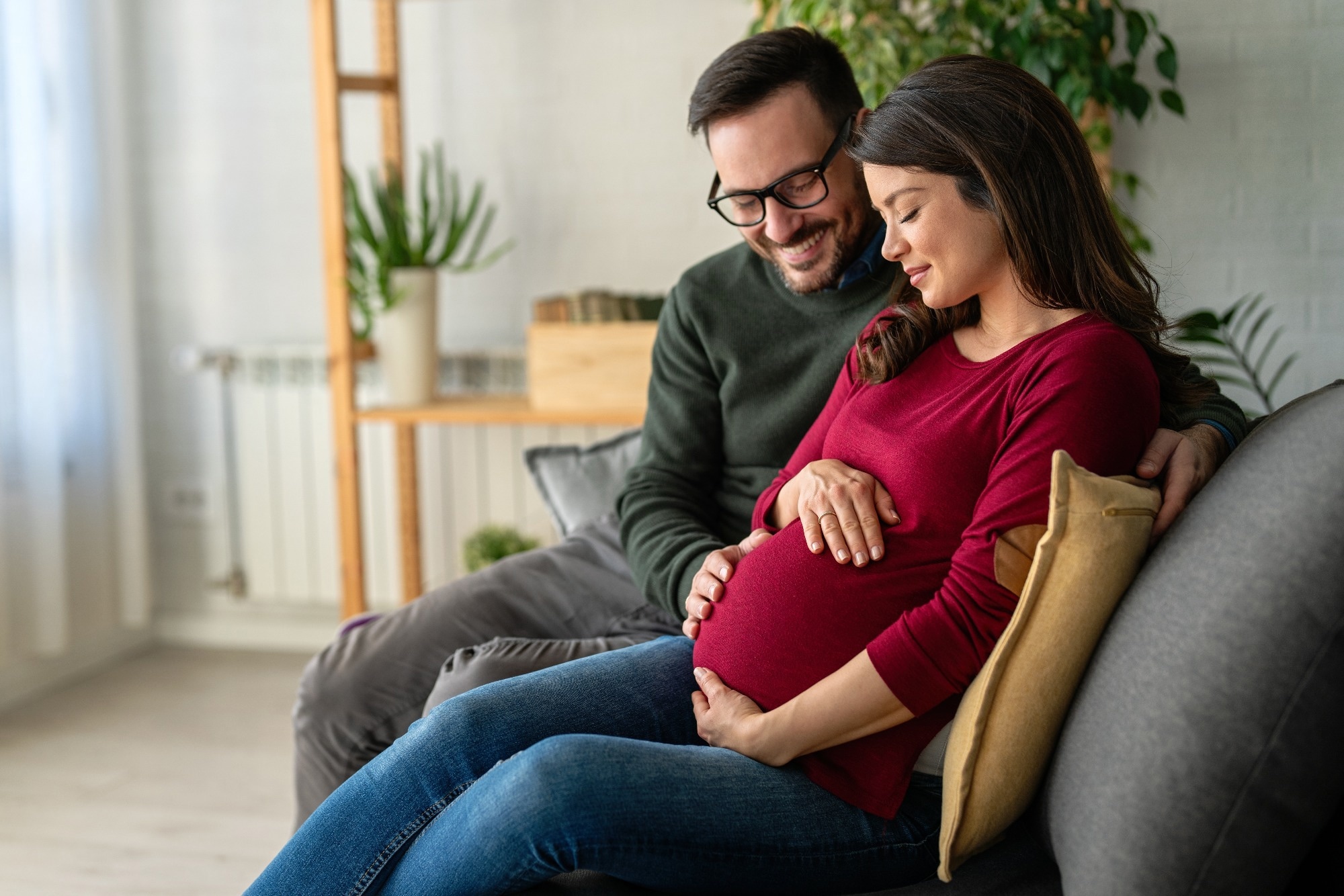 Man in love hugs his pregnant wife, they are waiting together for the baby
